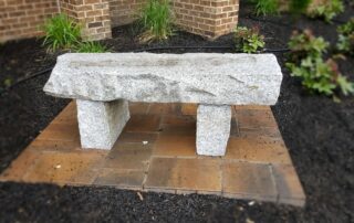 A stone bench sits in a garden