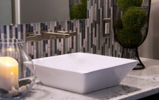 A sink raised above a bathroom vanity